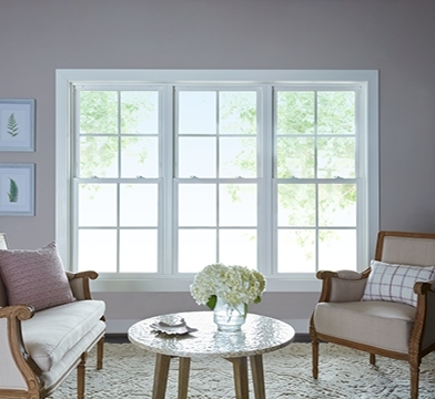 three white single-hung windows on a pink living room wall