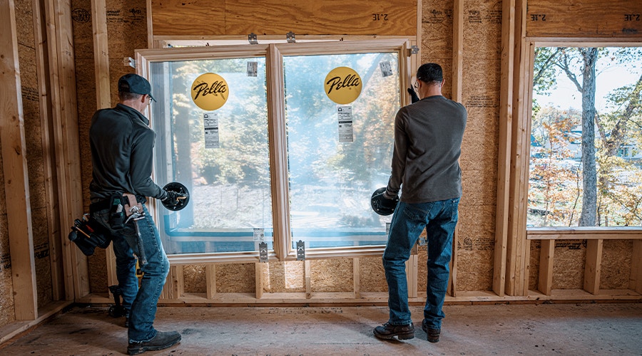 two men installing a wood window unit