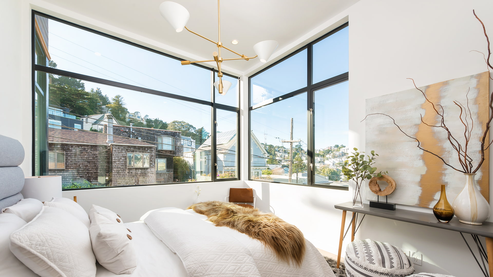 A plush master bedroom with a corner unit of aluminum windows