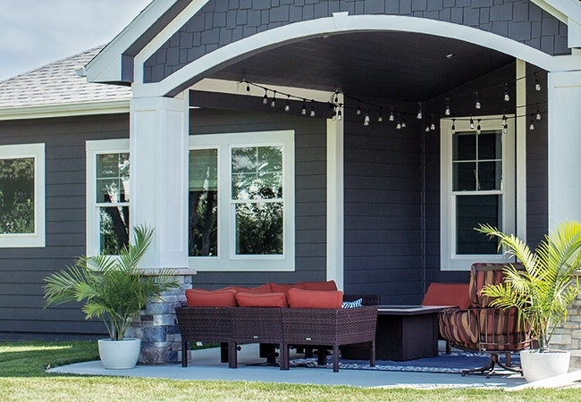 a cottage-style home exterior with edison lights over the deck
