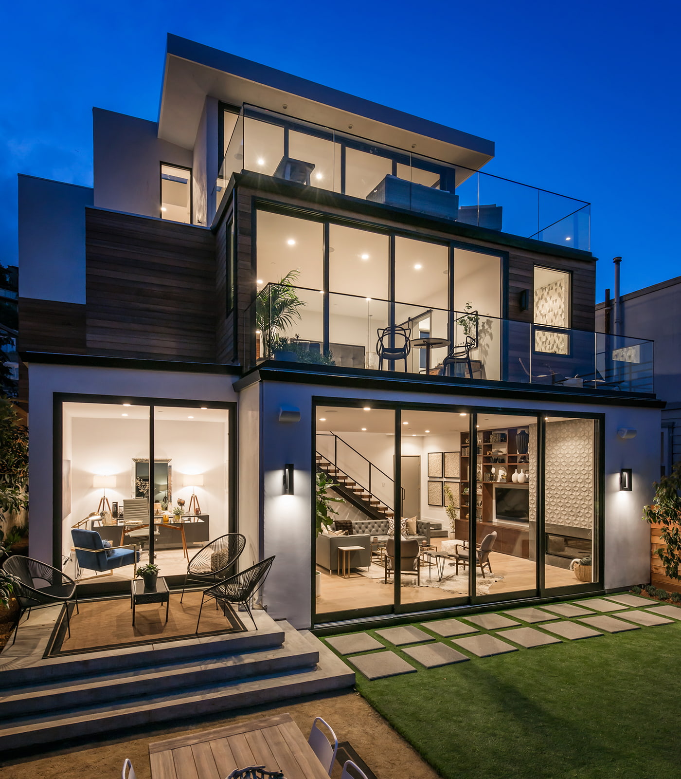 A contemporary three-story home viewed from the back