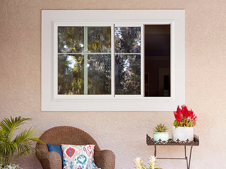 a sliding window on a stucco wall above a wicker chair
