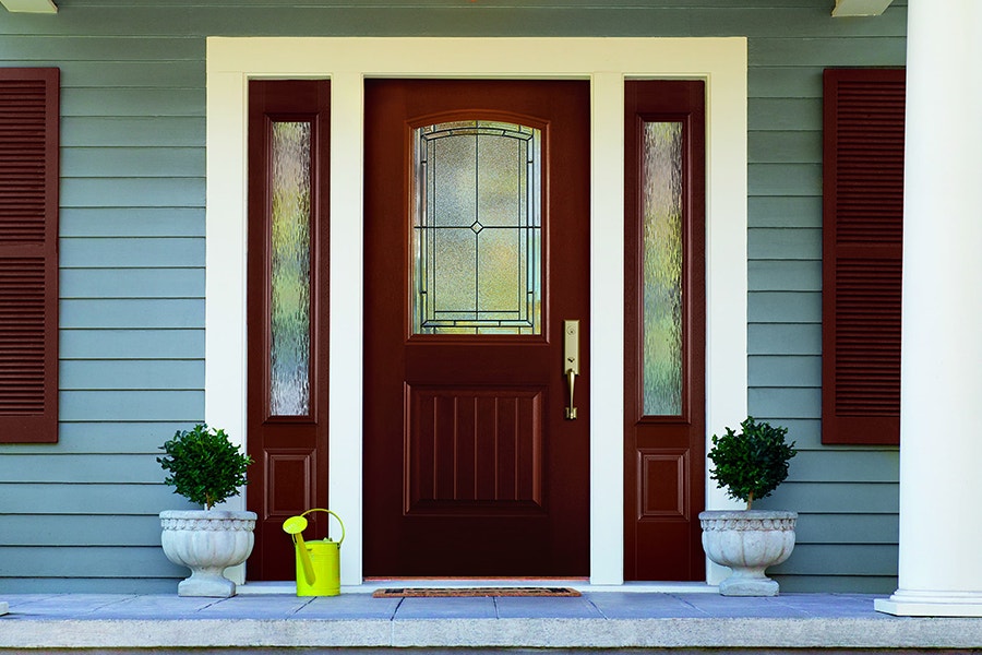 a fiberglass front door with decorative glass on the door and also the sidelights