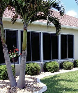 a coastal home with four sets of sunroom windows