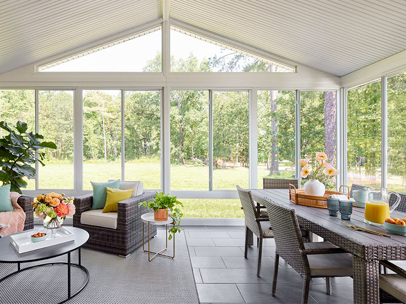 large sunroom glass sliding windows table and armchairs
