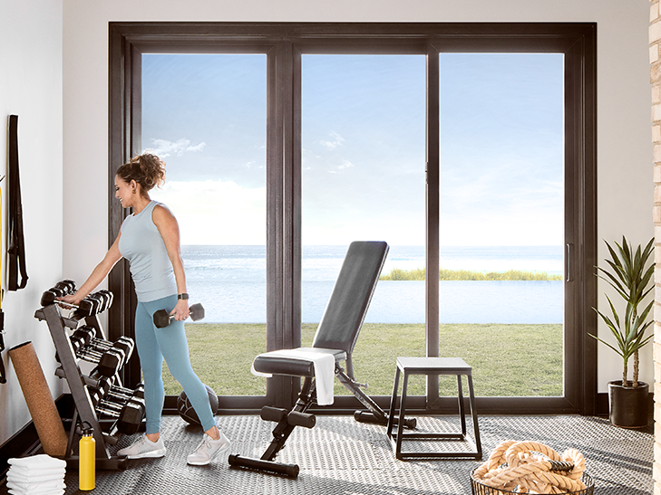 a woman is working out in front of a sliding patio door that is closed