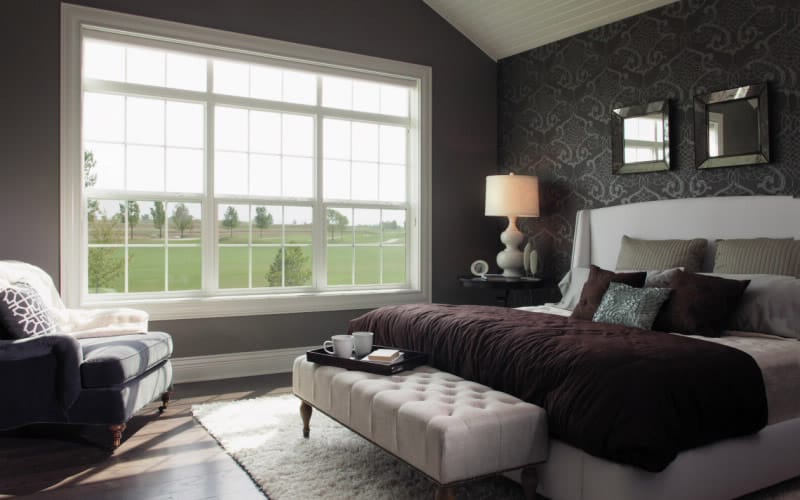 three single-hung windows in a dark-colored bedroom
