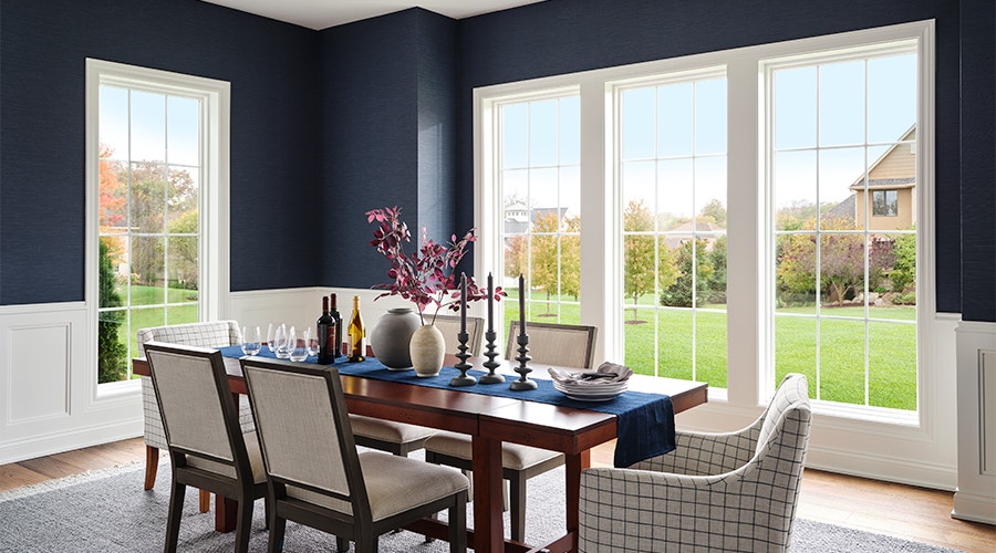 white fixed windows behind a traditional dining room table