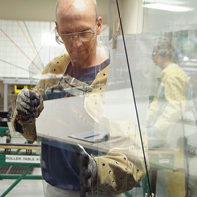 An Ocala CWS employee is working on a piece of glass