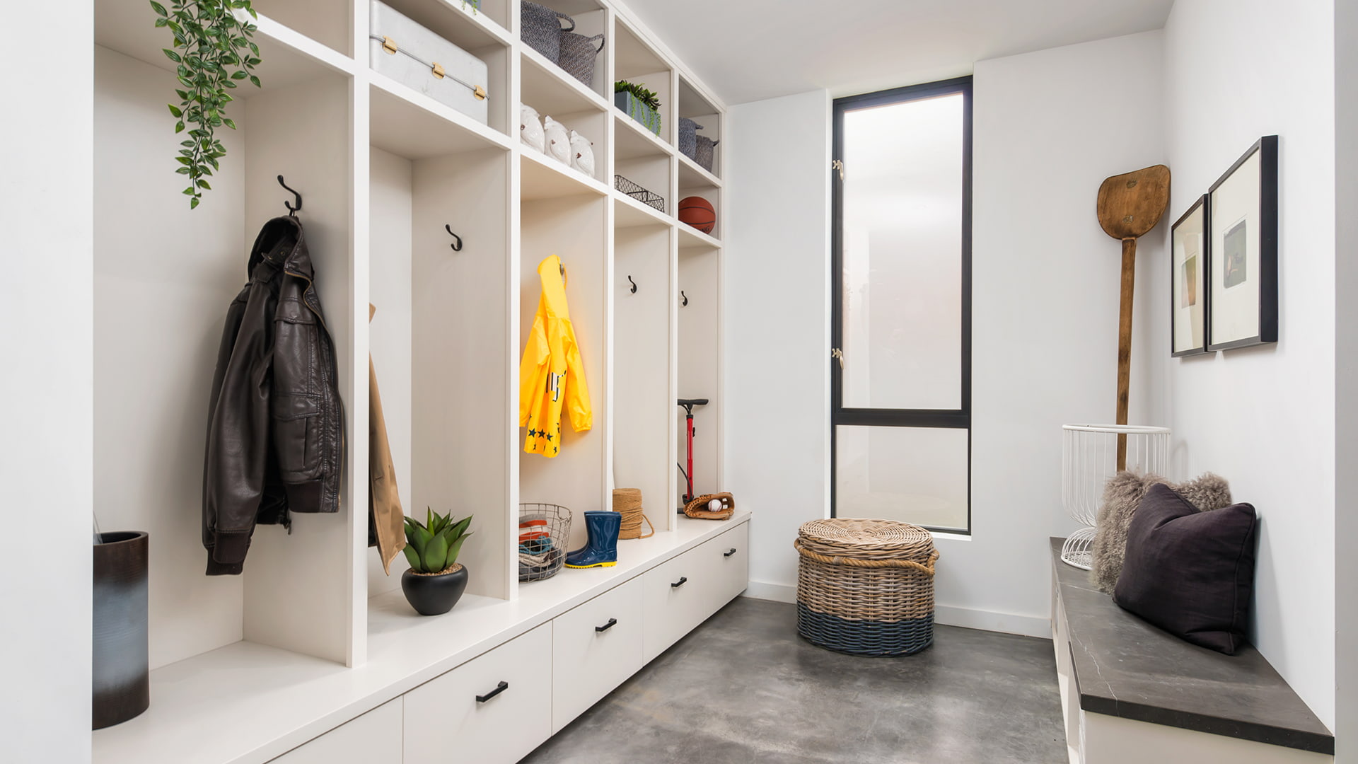 opaque window in a mudroom with cubbies for coats and boots