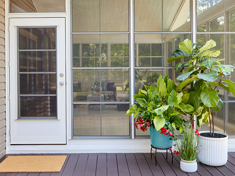 potted plants in front of a vinyl vertical sliding window