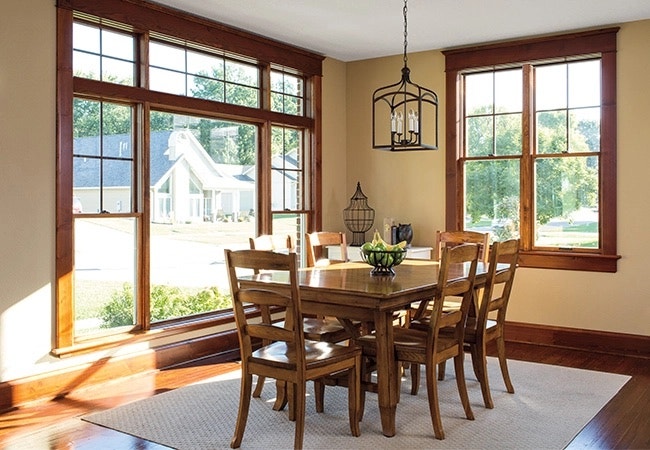 wood dining room set in a living room with wood windows
