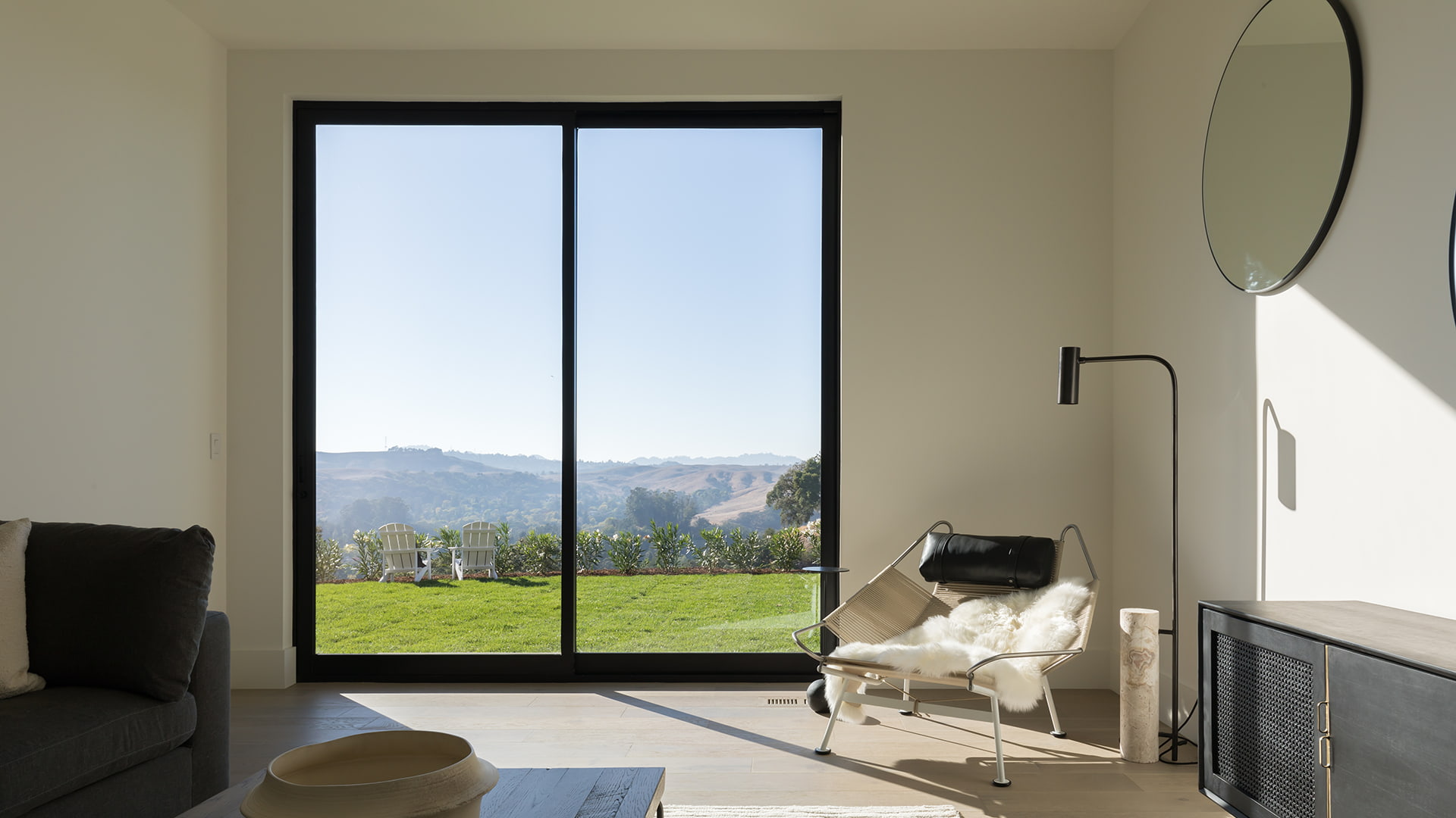 A black sliding patio door behind a contemporary lounge chair