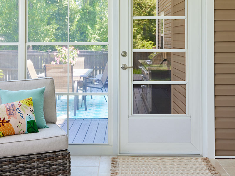 sunroom windows next to a hinged door with a screen