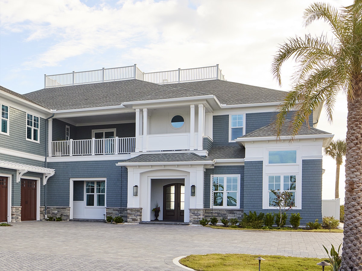 a palm tree beside a two-story beachside home