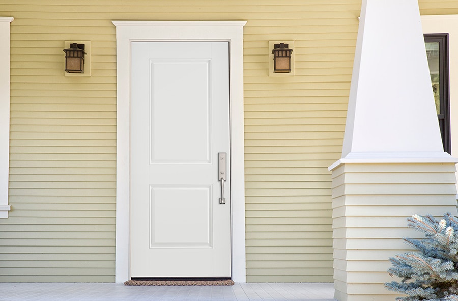 A white steel front door on a home with yellow siding, which is also on the front columns.