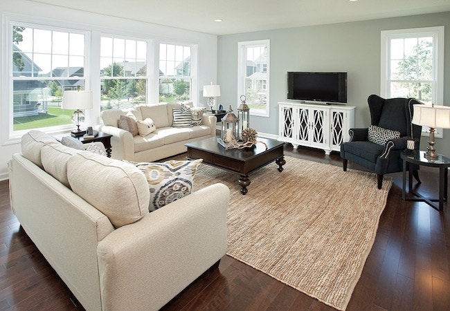 a traditional living room set with dark wood floors and gray walls