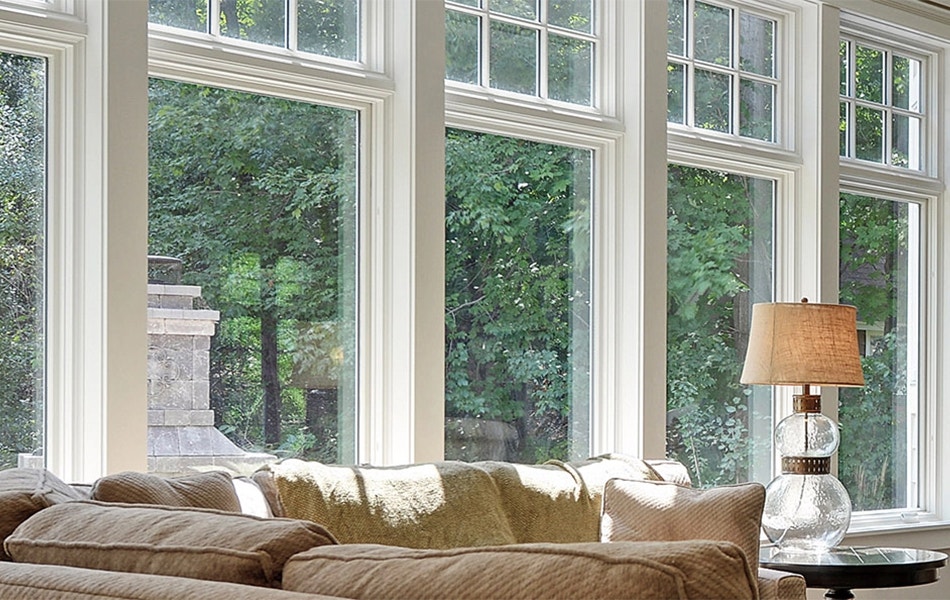 five traditional casement windows with transoms over each in front of a tan couch