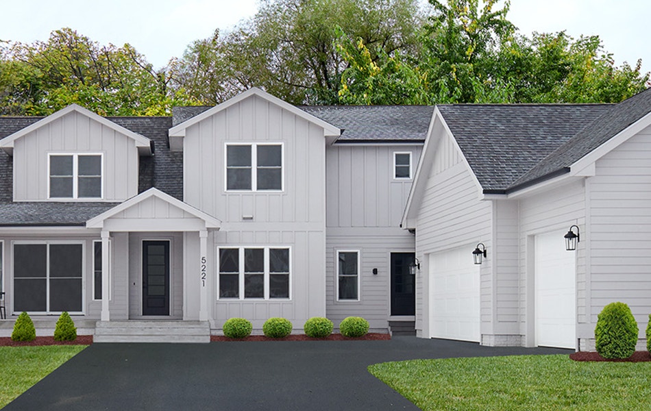 a large gray home set on a corner with white windows