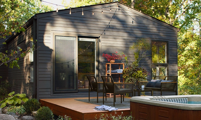 a couple is sitting at a patio with large single-hung windows behind them