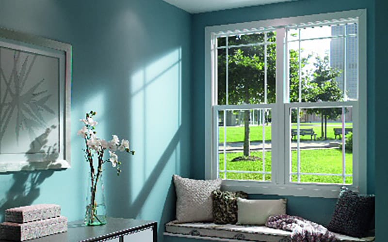 white vinyl double-hung windows against a teal wall