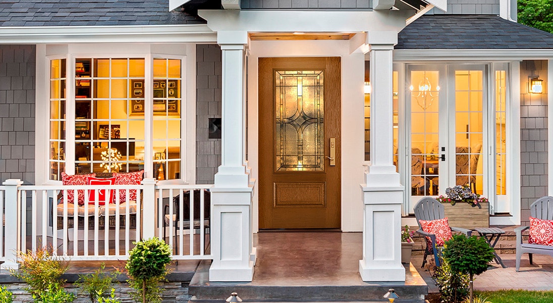 traditional home at dusk with a lot of interior light shining through