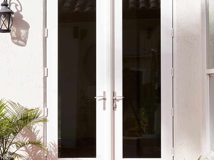 a white sliding patio door on a blue home exterior