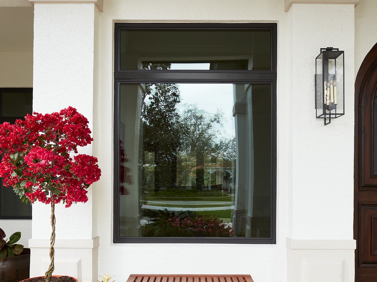 Dark tinted picture window on a white stucco home