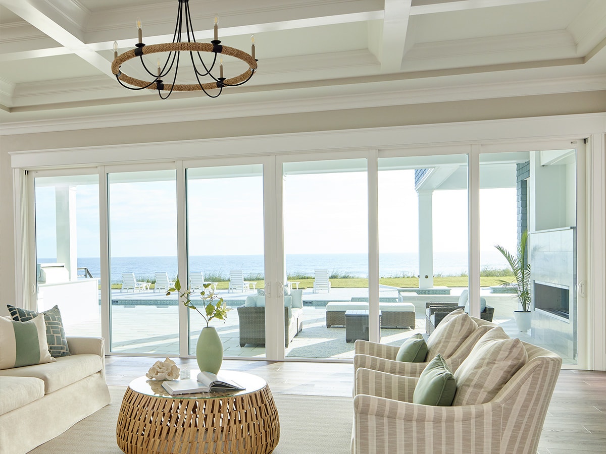 An expansive 8-panel sliding door between a coastal living room and the ocean