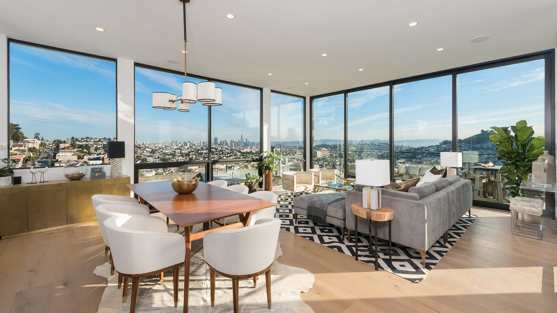 An open-concept living room surrounded by expansive pocket doors and floor-to-ceiling window units