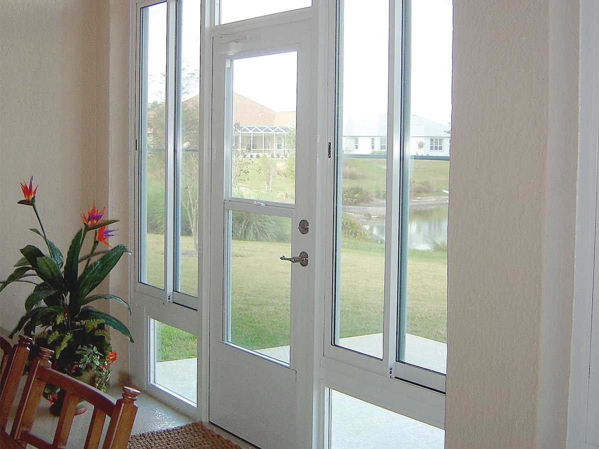 a white hinged sunroom door opens to a golf course