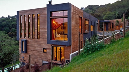 A contemporary hillside home with a dramatic extended window frame