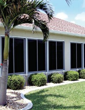 four acrylic sliding sunroom windows next to a palm tree