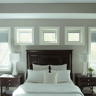 five windows surround a bed and side tables