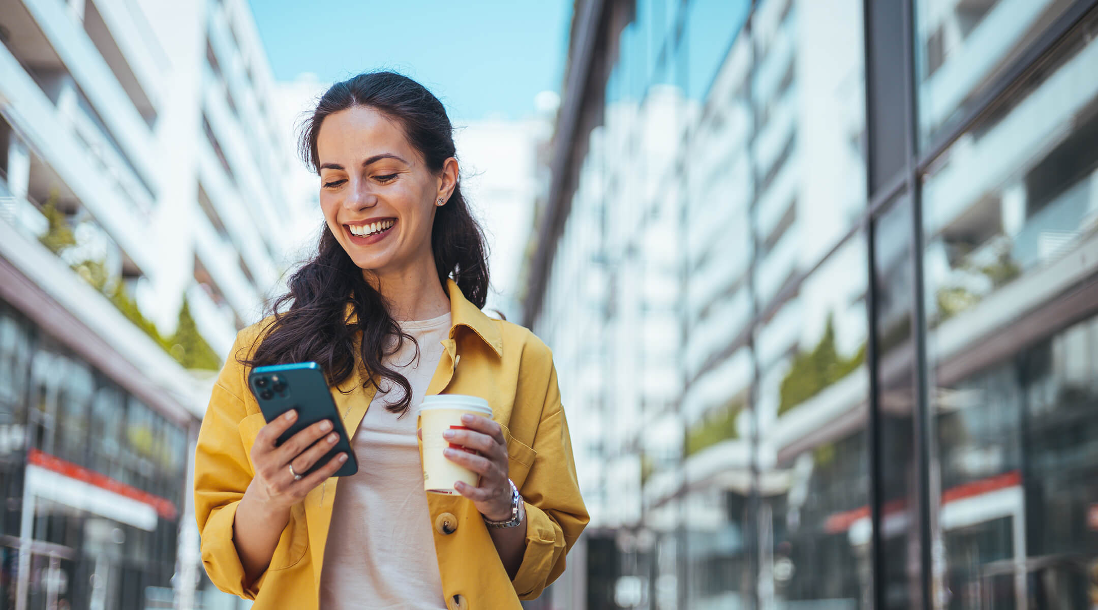 Woman on phone walking through a city