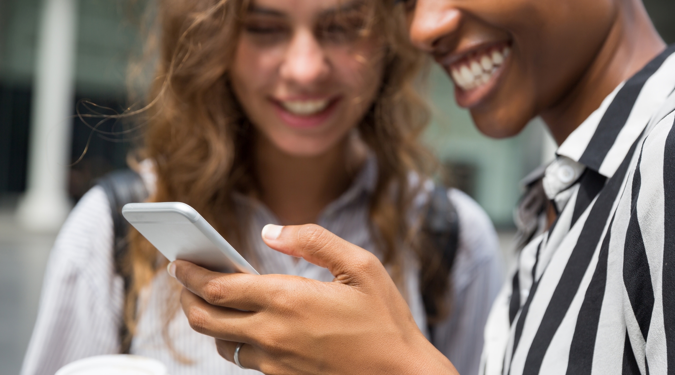 Two people using a mobile phone to research online loans