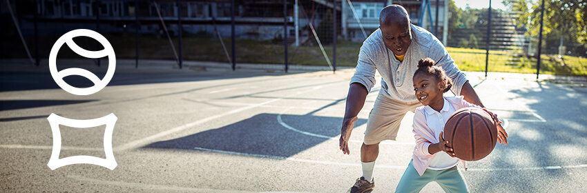Grandfather playing basketball with his granddaughter.
