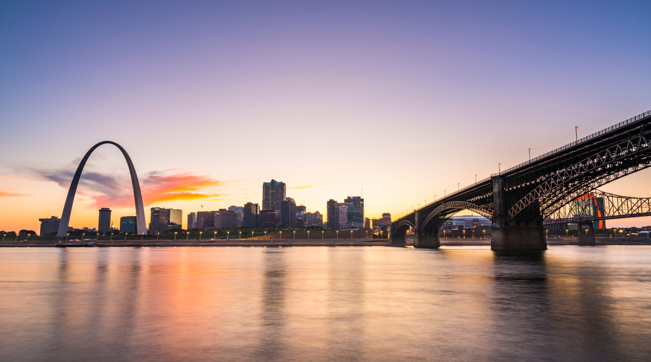 Sunset view of downtown looking across a bridge over a river in Missouri