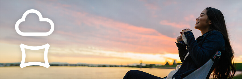 Woman relaxing outdoors with coffee, watching the sunset