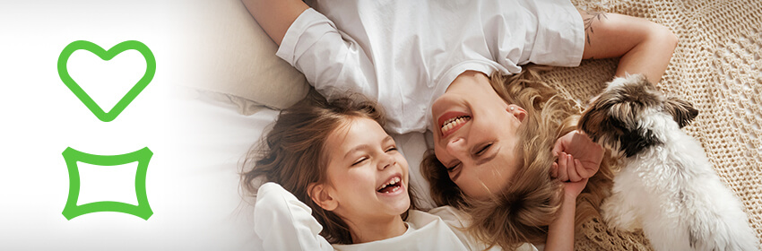 Mother and daughter laughing while playing with their dog.