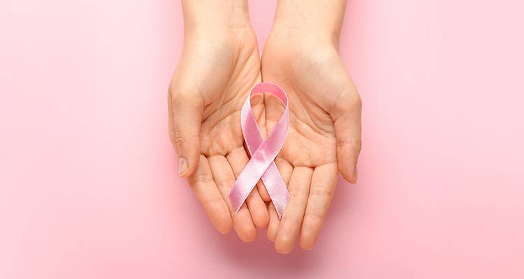 Woman holding pink ribbon for breast cancer awareness in her hands 