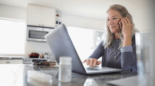 Woman on the phone by a laptop