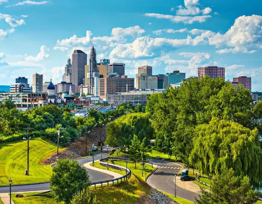 Hartford skyline with greenery and a road in the foreground.