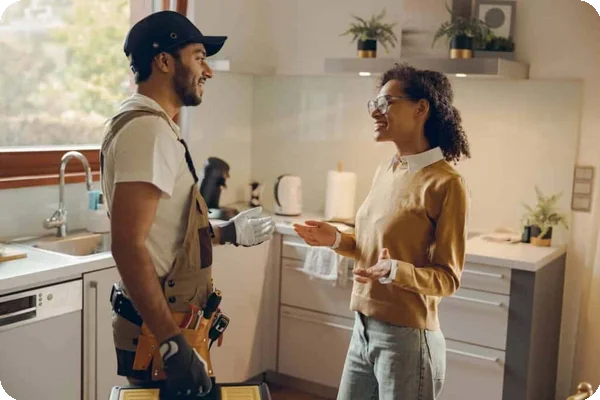 A woman chats happily with a contractor wearing a tool belt
