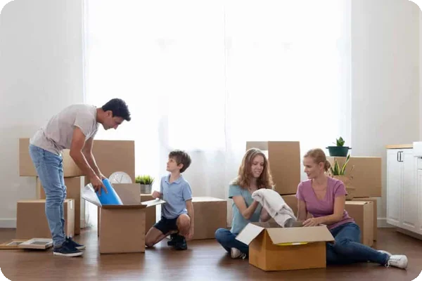 A family packs boxes with towels and other necessities