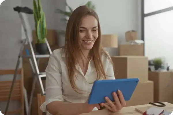 Woman reviewing a moving checklist surrounded by packed boxes