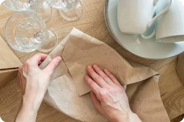 An aerial shot of someone wrapping a dish with packing paper