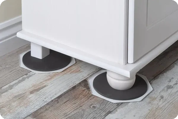 Furniture sliders placed under a cabinet to protect wood floors during a move