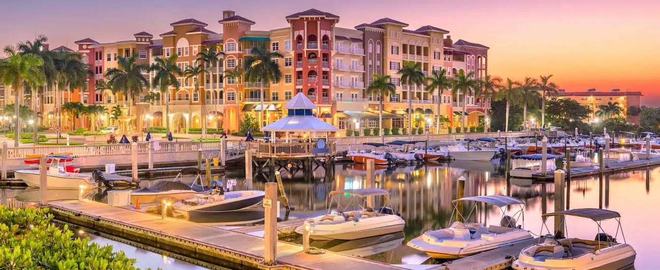 A view of a marina filled with boats at nighttime in Naples, FL