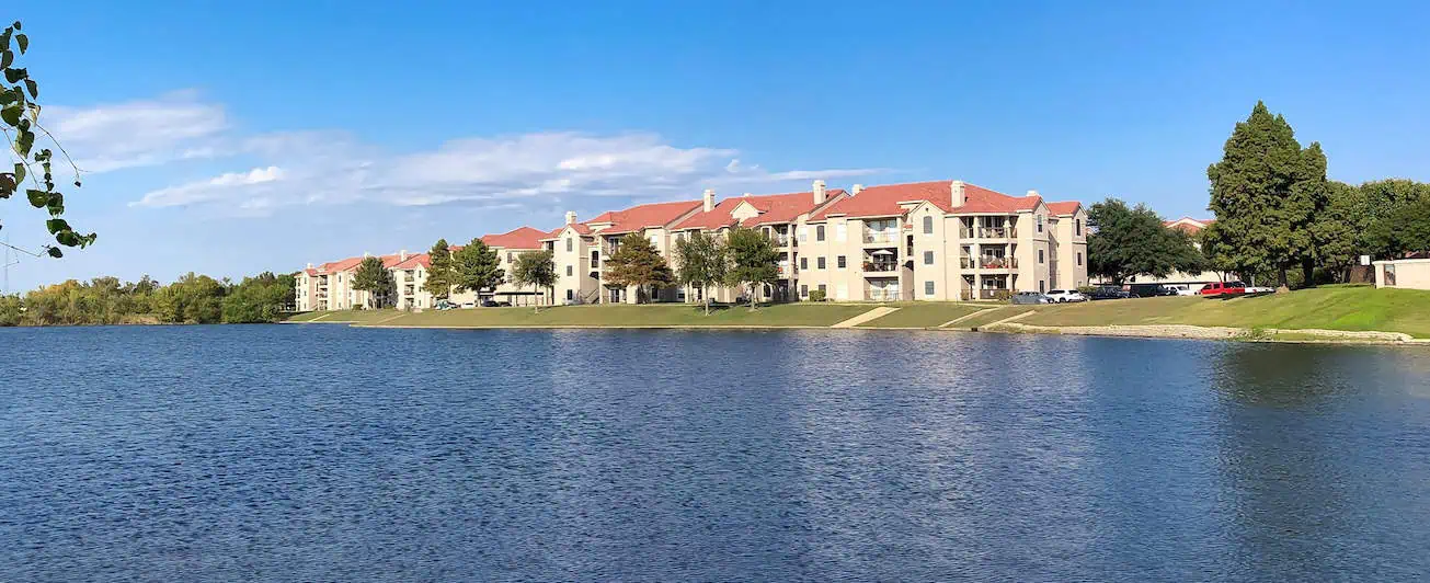 A view of lakeside homes with red roofs and white walls in Lewisville, TX